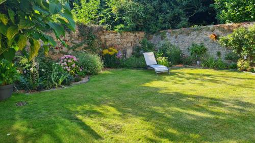 a chair sitting in the middle of a yard at Chez Fabienne et Olivier, chambre privative avec SDB et WC, Avranches Baie du Mont Saint Michel in Avranches