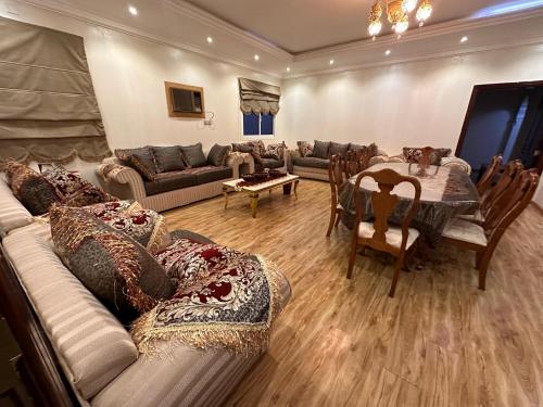 een woonkamer met een bank, een tafel en stoelen bij شقق مفروشة 22 in Al Madinah