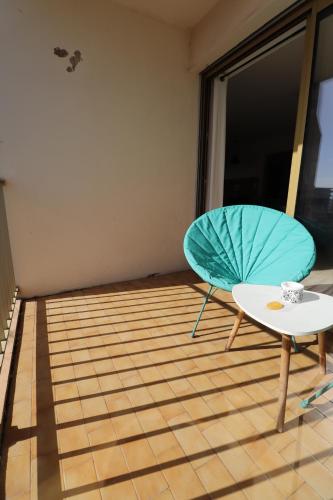 a room with a table and a blue umbrella at Sublime Appartement avec Parking Privé à Ajaccio in Ajaccio