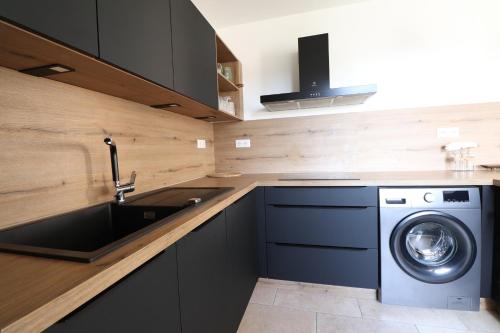 a kitchen with a sink and a washing machine at Sublime Appartement avec Parking Privé à Ajaccio in Ajaccio