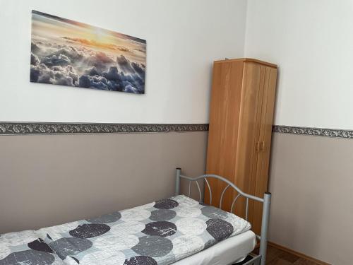 a bedroom with a bed and a painting on the wall at Pension&Hostel Anna - Monteurzimmer -------- 10 minutes walk to Oktoberfest in Munich
