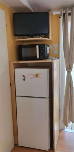 Il comprend une cuisine équipée d'un réfrigérateur et d'une télévision. dans l'établissement Mobilhome 3 chambres, à Noyelles-sur-Mer