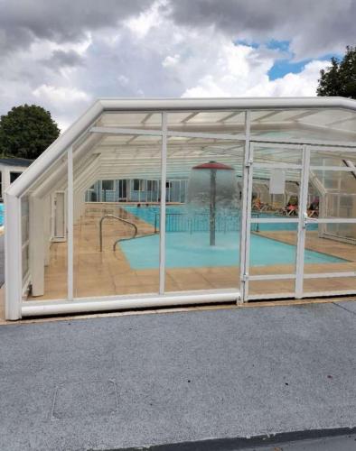 un grand bâtiment en verre avec une piscine intérieure dans l'établissement Mobilhome 3 chambres, à Noyelles-sur-Mer