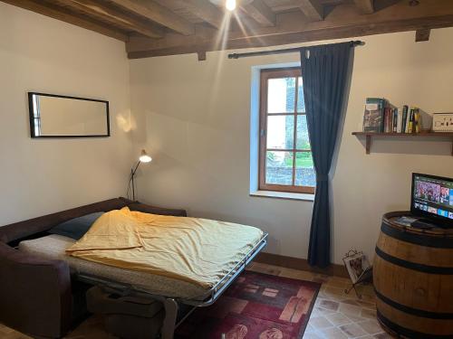 a small bedroom with a bed and a window at Le Cercotin in Moroges