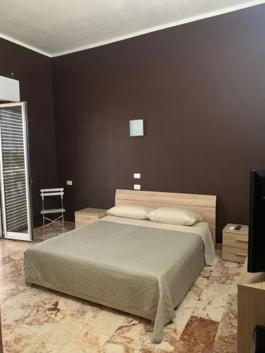 a bedroom with a bed and a black wall at B&B AFFITTACAMERE Mo' MONTEIASI in Monteiasi