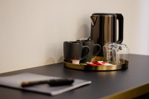 a coffee maker on a table with a remote control at Hotel Atria in Braşov