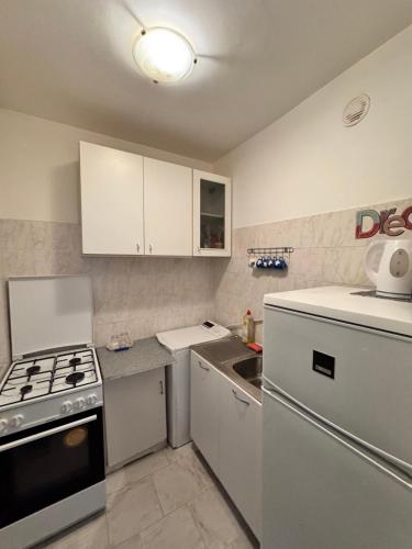 a kitchen with white cabinets and a stove top oven at Cozy Apartments in Bacău