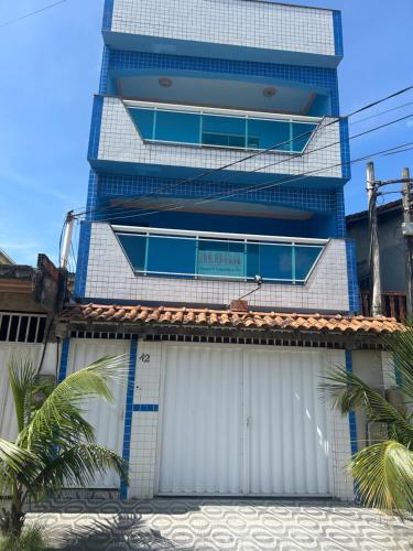 a tall building with a garage in front of it at Romar Temporadas in Cabo Frio