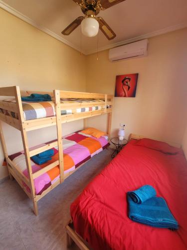 a bedroom with two bunk beds and a red bed at casa des loups in Ciudad Quesada