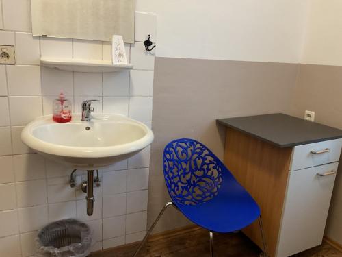 a bathroom with a sink and a blue chair at Pension&Hostel Anna - Monteurzimmer -------- 10 minutes walk to Oktoberfest in Munich