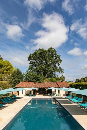 - une piscine avec des chaises et un arbre dans l'établissement Les Bernardies, à Simeyrols