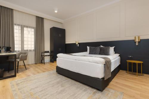 a bedroom with a large bed and a desk and a table at Hotel Atria in Braşov
