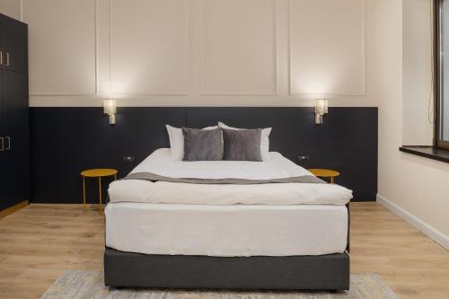 a large bed in a room with two tables at Hotel Atria in Braşov