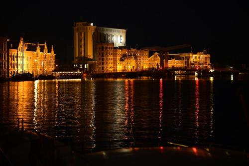 a city at night with lights on the water at B&B Teddy "Prachtig authentiek woonschip uit 1912, 15 minuten van Amsterdam" in Wormer