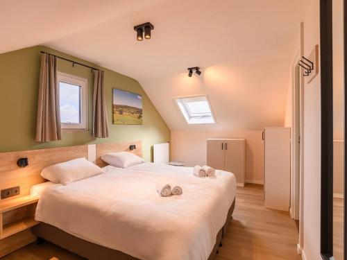 a bedroom with a large bed with two towels on it at Bungalow in Reevallis near Scenic Hills in Vijlen