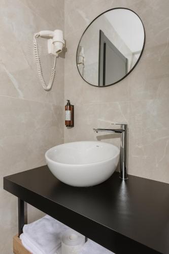a bathroom with a white sink and a mirror at Hotel Atria in Braşov
