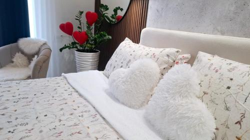 a bed with two stuffed teddy bears on it at Josephine Apartment in Subotica