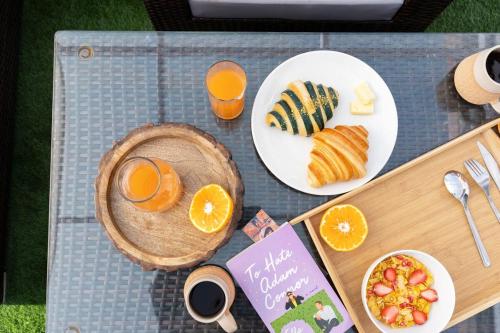 a table topped with plates of food and orange juice at Premium 2BR Apartment in Kathmandu near Thamel 3 in Kathmandu