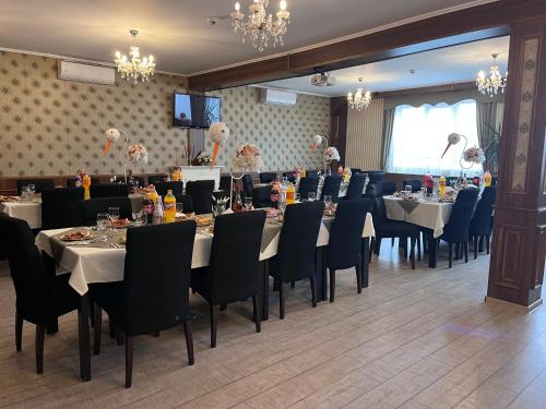 a dining room with tables and chairs and a room with chandeliers at Pensiune cu restaurant Bigfast in Luduş
