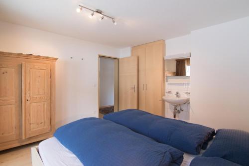 a bedroom with a blue bed and a sink at Mischi 5 in Saas-Fee