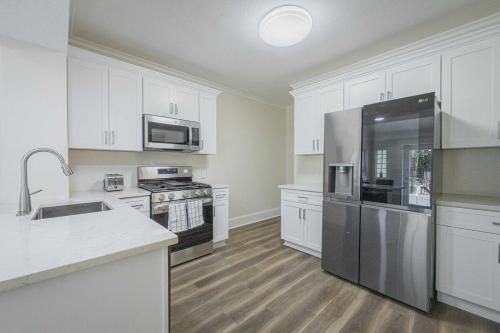 a kitchen with white cabinets and stainless steel appliances at Five Points Mill House in Athens