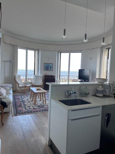 une cuisine avec un évier et un salon dans l'établissement Appartement Trouville Palace, à Trouville-sur-Mer