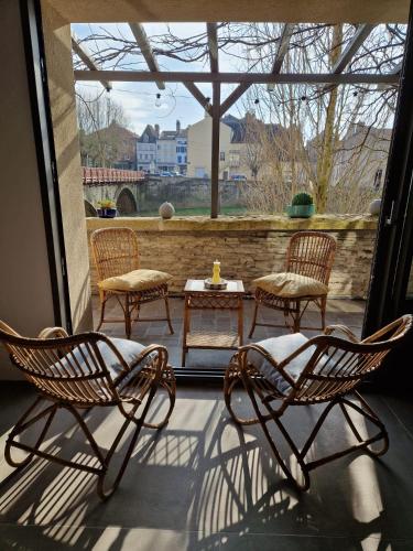 3 chaises et une table sur une terrasse avec vue dans l'établissement L'atelier du Doubs, à Verdun-sur-le-Doubs