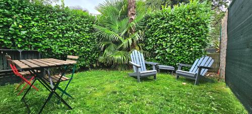 - deux chaises et une table de pique-nique dans la cour dans l'établissement T2 avec jardin proche des plages, à Bénodet