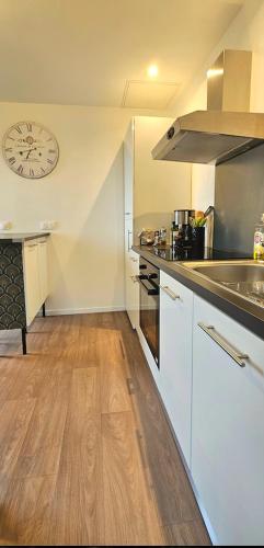 une cuisine vide avec une horloge sur le mur dans l'établissement T2 avec jardin proche des plages, à Bénodet