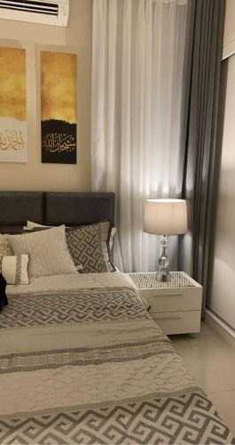 サラーラにあるLovely one bedroom with nice weather and viewsのベッドルーム(ベッド1台、ランプ、カーテン付)