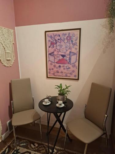 two chairs and a table in a room with a painting at Paradiso Nascosto del Lago Maggiore in Colazza
