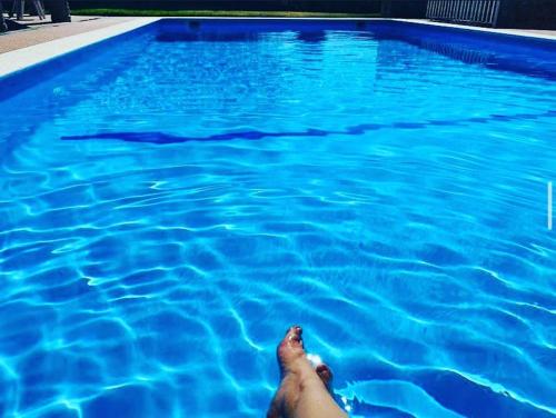 a person laying in a pool of blue water at Quinta da Memória Village in Vimieiro