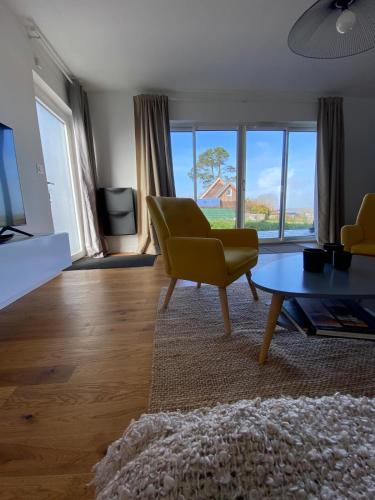 un salon avec une chaise jaune et une table dans l'établissement Maison neuve 4 personnes TELGRUC SUR MER 2 chambres, à Telgruc-sur-Mer