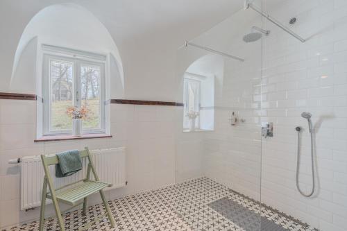 a white bathroom with a shower and a chair at Palitz No 17 - venkovské stavení in Lipová