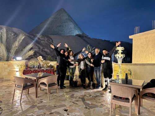 a group of people standing in front of the pyramid at Crystal pyramid inn in Cairo