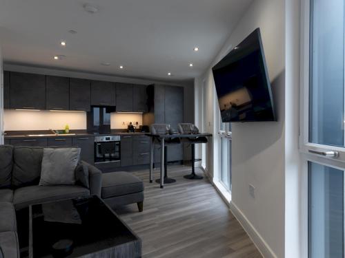 a living room with a couch and a tv and a kitchen at Pass the Keys Penthouse apartment Stunning Views in Chelmsford
