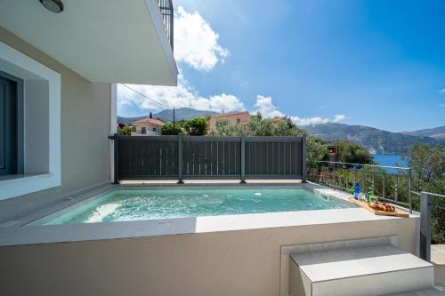 a swimming pool on the balcony of a house at Assos Rockshore Villa by the sea in Asos