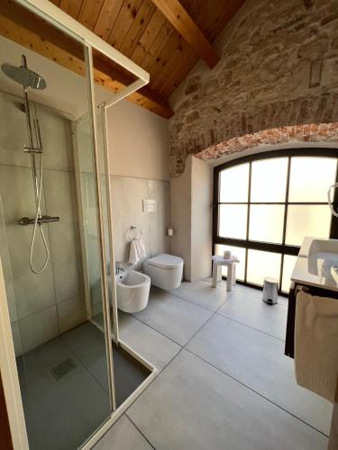 a bathroom with a glass shower and a toilet at NUOVA FILANDA Rooms and More in Valdobbiadene