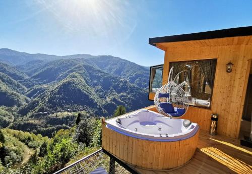 a jacuzzi tub on a deck with a view of mountains at Eco House Merisi in Merisi