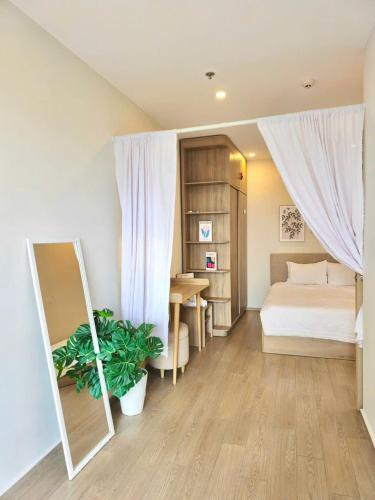 a bedroom with a bed and a table and a mirror at Cloud Nine The Song Vung Tau Homestay in Vung Tau