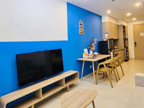 a living room with a large flat screen tv on a blue wall at Cloud Nine The Song Vung Tau Homestay in Vung Tau