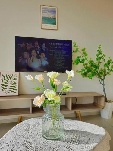 a vase with flowers sitting on a table at Cloud Nine The Song Vung Tau Homestay in Vung Tau