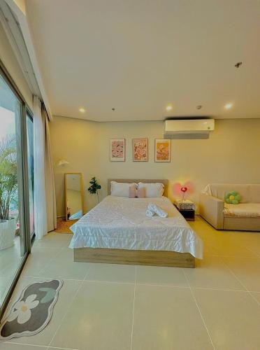 a bedroom with a large bed and a couch at Cloud Nine The Song Vung Tau Homestay in Vung Tau