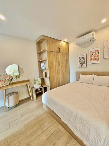 a bedroom with a white bed and a desk at Cloud Nine The Song Vung Tau Homestay in Vung Tau
