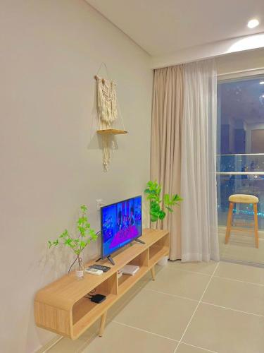 a living room with a television on a wooden table at Cloud Nine The Song Vung Tau Homestay in Vung Tau