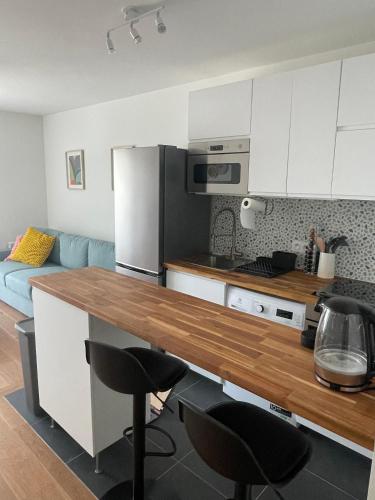 une cuisine avec un comptoir en bois dans une pièce dans l'établissement New & serene II 1 bedroom appartement near La Défense Paris Parking and Fibre, à Suresnes