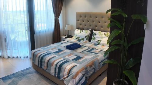 a bedroom with a bed with a quilt and pillows at Dominiks Comfort and silent Studio Tambuli Balcony Pool Mactan Ocean View High Floor in Lapu Lapu City