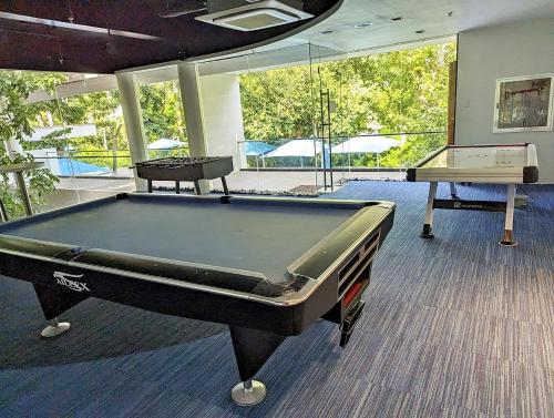 a room with a pool table and two tables at Dominiks Comfort and silent Studio Tambuli Balcony Pool Mactan Ocean View High Floor in Lapu Lapu City