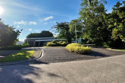 a road with a building and some grass and trees at Dominiks Comfort and silent Studio Tambuli Balcony Pool Mactan Ocean View High Floor in Lapu Lapu City