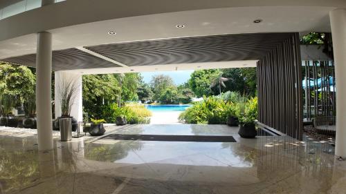 an open lobby with a pool in the background at Dominiks Comfort and silent Studio Tambuli Balcony Pool Mactan Ocean View High Floor in Lapu Lapu City